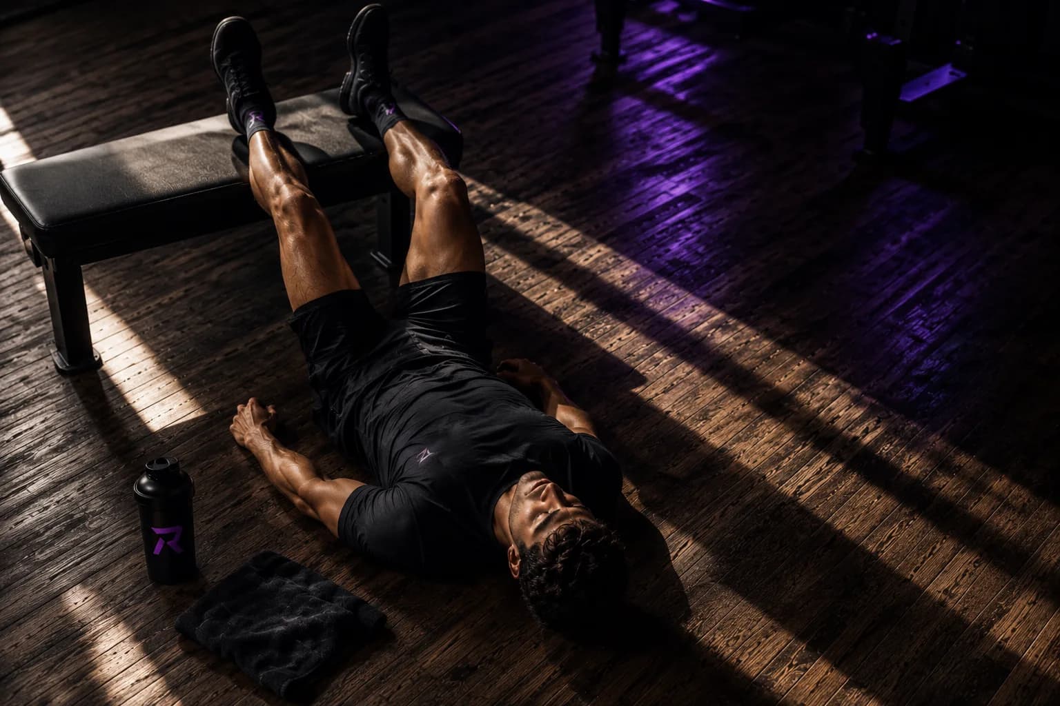 Man ligt na de training op de vloer met de benen omhoog tegen de bank, laag paars licht
